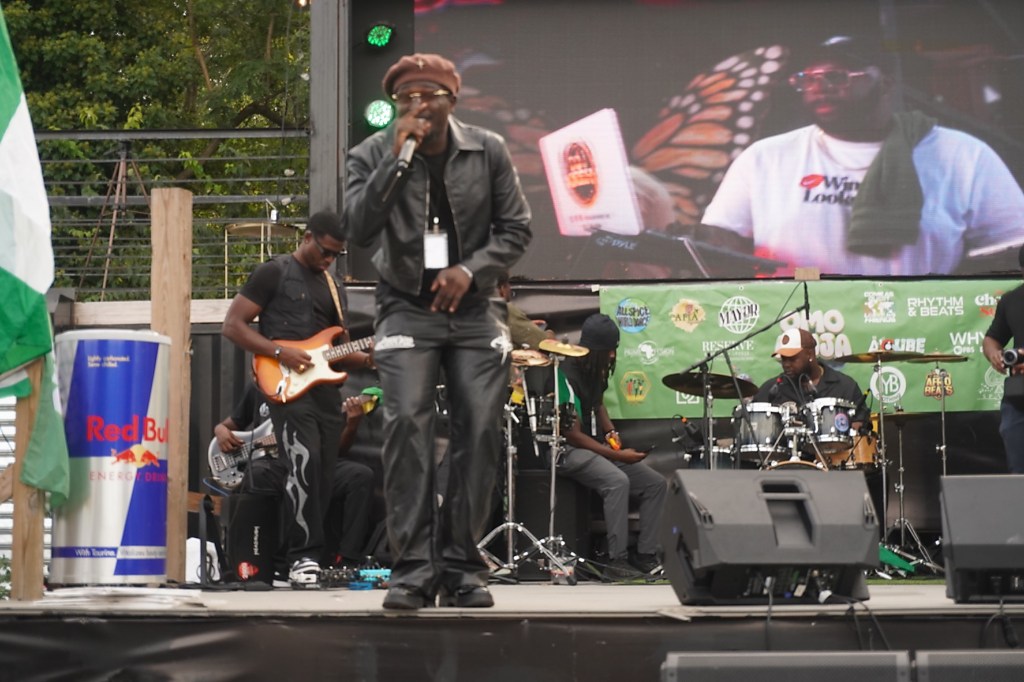 Performer singing with a live band at the Omo Naija Festival in Philadelphia.